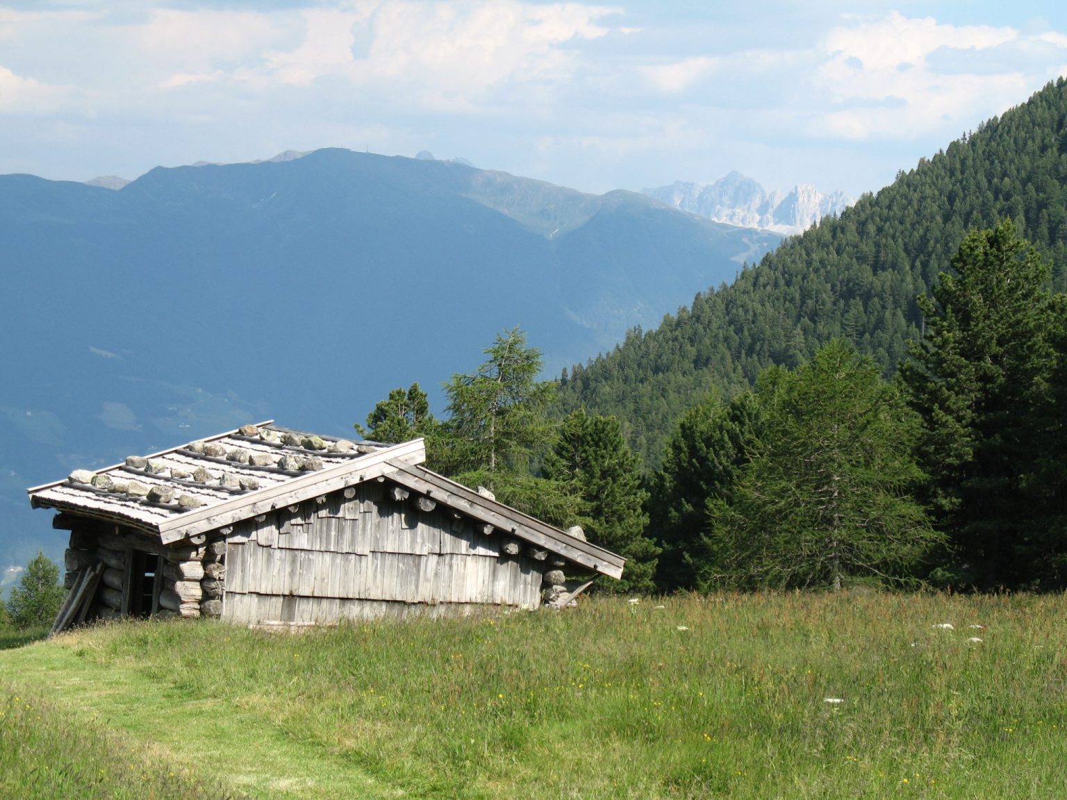 Blick von der Zermaitalm über eine Almhütte auf die Geislerspitzen 